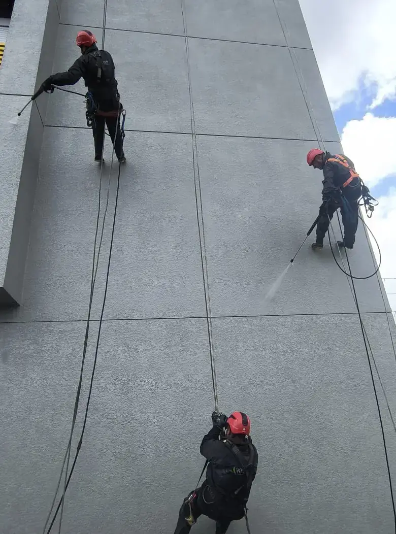 Equipe em trabalho de limpeza de fachada