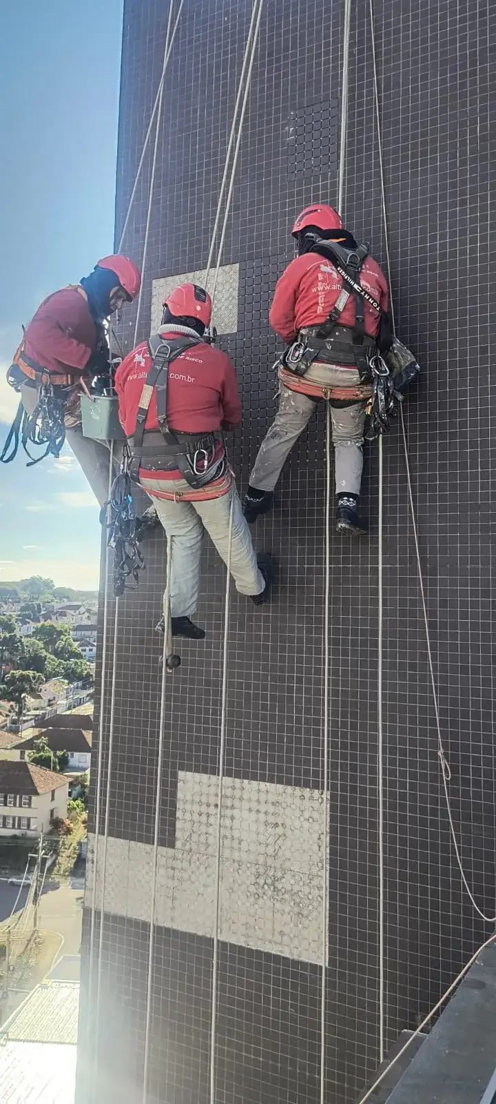 Equipe em manutenção de fachada com pastilhas